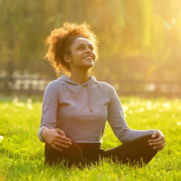relaxed woman sitting in grass