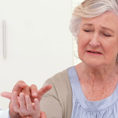 doctor looking at senior woman's hands
