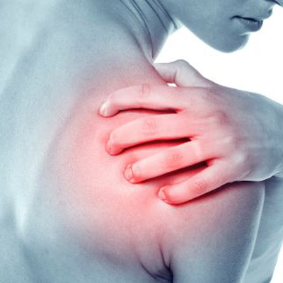 woman holding shoulder in pain