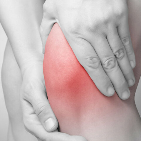 holding knee in pain